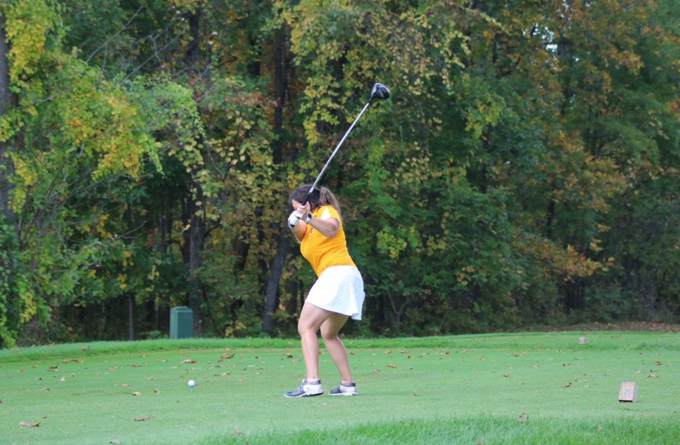 SC4 women's golfer swinging at a golf ball